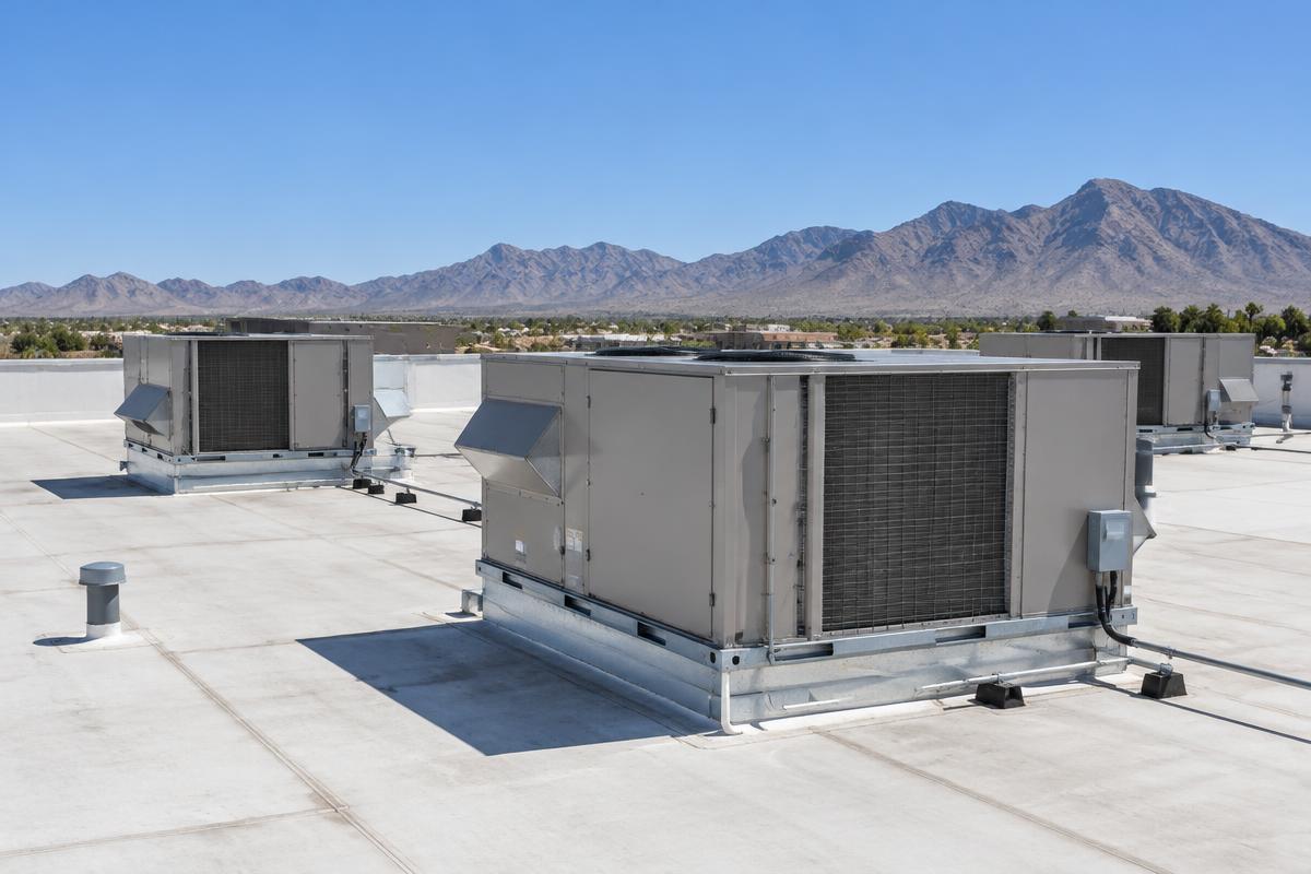 Representative photo: commercial rooftop HVAC package units with desert mountains behind